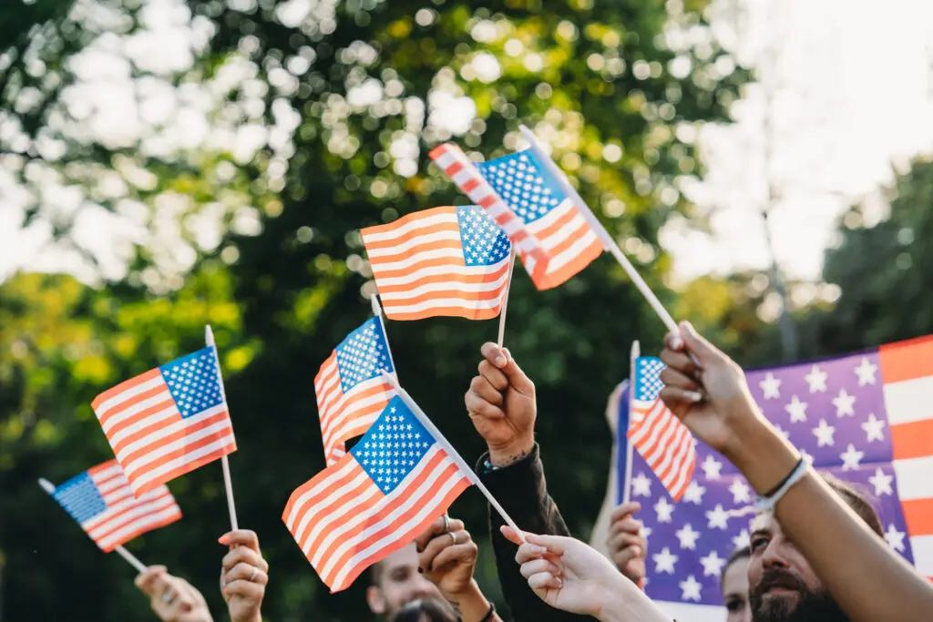 people waving flags at a memorial day parade
